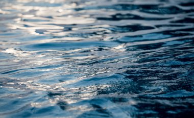 Mavi okyanus dalgalarının detaylı bir su yüzeyi görüntüsü..