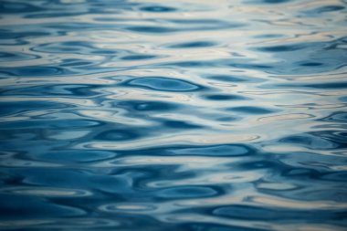 Mavi okyanus dalgalarının detaylı bir su yüzeyi görüntüsü..