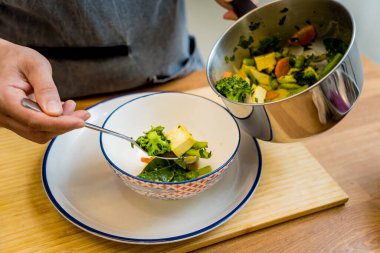 Aşçı mutfakta yeşil köri hazırlıyor otlar ve pirinçle.