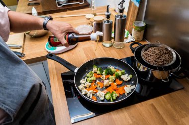 Şef mutfakta mercimekli Japon karabuğday makarnası hazırlıyor..
