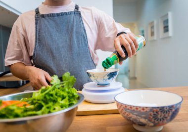 Şef mutfakta baharatlı cam erişte salatası hazırlıyor..