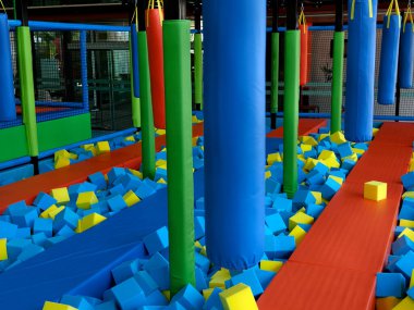 Trambolin parkında çocuklar için mavi ve sarı köpük küpleri var..