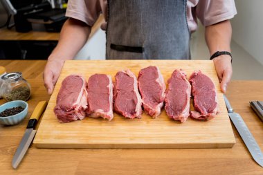 Kesme tahtasındaki biftekler için çiğ biftek eti..