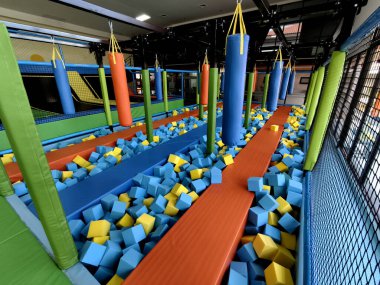 Trambolin parkında çocuklar için mavi ve sarı köpük küpleri var..