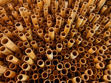 Background of bamboo tubes are arranged in a stack on top of one another. clipart