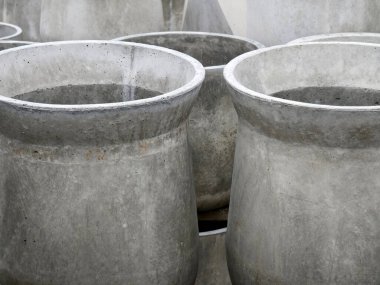 Birkaç beton saksısı üst üste yığılmış..