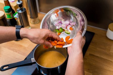 Şef mutfakta tatlı patates ve baharatlı masör körisi hazırlıyor..