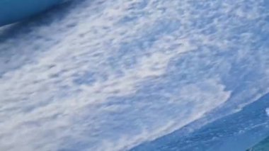 Su parkında dalga simülatöründe sörf yapan genç bir adam..