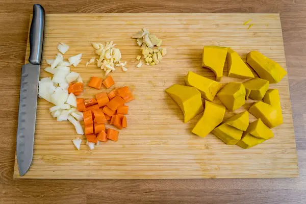 Tofu ve sebzeli balkabağı lapası hazırlamak için malzemelerle tahta kesmek..