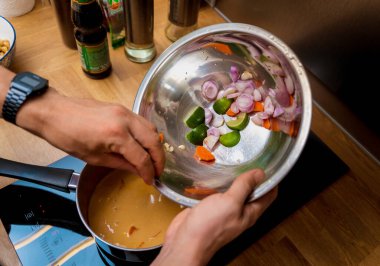 Şef mutfakta tatlı patates ve baharatlı masör körisi hazırlıyor..