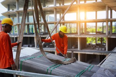 İnşaat halindeki bir binada işçiler vinçten levha alıyorlar..