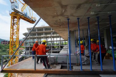 İnşaat halindeki bir binada işçiler vinçten levha alıyorlar..