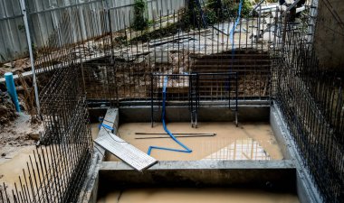 Çelik demirle güçlendirilmiş beton temeli gösteren bir inşaat alanı..