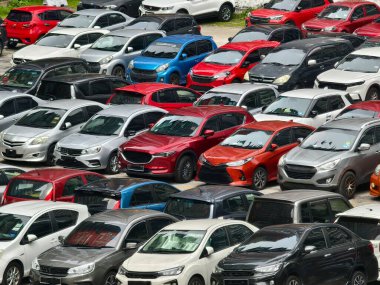 Büyük bir otoparkta park edilmiş çok sayıda araba var..