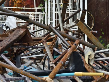 Çöp yığını, bir kova, halat, şişeler ve çöp sahasında diğer eşyalar..