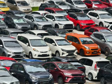 Büyük bir otoparkta park edilmiş çok sayıda araba var..