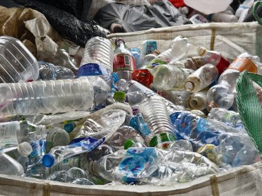 Bir poşetin içinde büyük bir plastik şişe ve kutu yığını var..