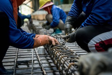 Bir grup inşaatçı metal bir yapı inşa etmekle meşgul..