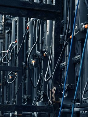 Bir grup elektrik kablosu ve konnektörler kurşun bir panelden sarkıyor..