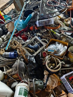 Çöp yığını, bir kova, halat, şişeler ve çöp sahasında diğer eşyalar..