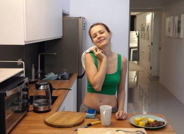 Genç bir kadın taze sebzeler kullanarak çeşitli sağlıklı yemekler hazırlıyor. 