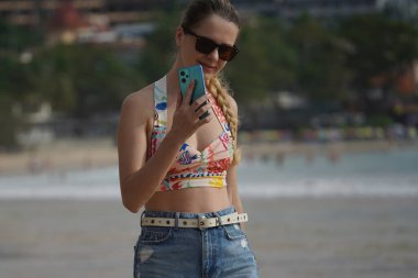 Genç bir kadın kumsalda güzel bir günün tadını çıkarıyor. 