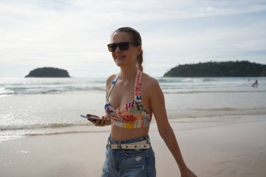 Genç bir kadın kumsalda güzel bir günün tadını çıkarıyor. 