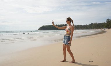 Genç bir kadın kumsalda güzel bir günün tadını çıkarıyor. 