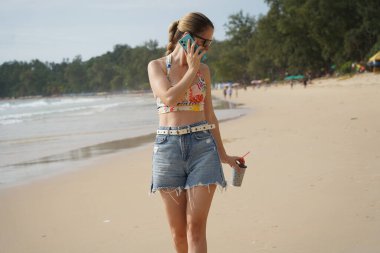 Genç bir kadın kumsalda güzel bir günün tadını çıkarıyor. 