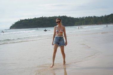 Genç bir kadın kumsalda güzel bir günün tadını çıkarıyor. 