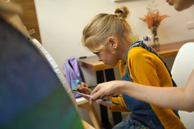 Bir anne ve kızı evde bir resim seansına katılıyorlar.