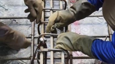 Bir grup inşaatçı metal bir yapı inşa etmekle meşgul..