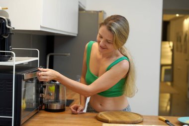 Genç bir kadın taze sebzeler kullanarak çeşitli sağlıklı yemekler hazırlıyor. 