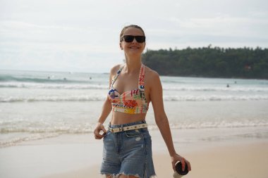 Genç bir kadın kumsalda güzel bir günün tadını çıkarıyor. 