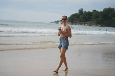 Genç bir kadın kumsalda güzel bir günün tadını çıkarıyor. 