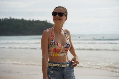 Genç bir kadın kumsalda güzel bir günün tadını çıkarıyor. 