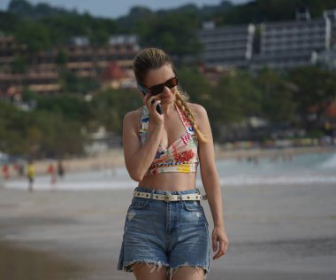 Genç bir kadın kumsalda güzel bir günün tadını çıkarıyor. 