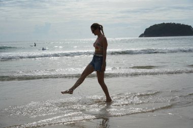 Genç bir kadın kumsalda güzel bir günün tadını çıkarıyor. 