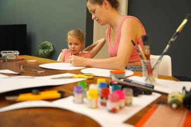 Bir anne ve küçük kızı, yaratıcılığı teşvik eden renkli bir resim faaliyetinde bulunuyorlar.