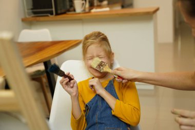 Sanat öğretmeni atölyede iki kıza termo mozaik montajı öğretiyor. 