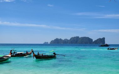 Huzurlu ve güzel bir tropikal plaj cenneti. Büyüleyici manzaralar ve manzaralara karşı geleneksel tekneler sergileniyor.