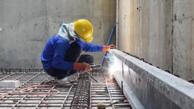 İşçiler inşaat alanındaki beton yapıların istikrarı için gerekli çelik parmaklıkları güçlendiriyorlar.