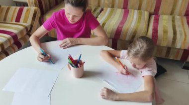 Bir anne ve kızı evde birlikte boyama faaliyetlerinde bulunuyorlar.