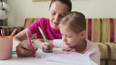 Bir anne ve kızı evde birlikte boyama faaliyetlerinde bulunuyorlar.