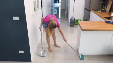 Bir kadın evinde şık oturma odasını temizliyor.