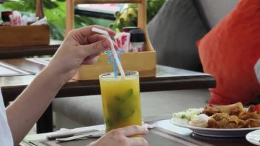 Bir kadın, modern bir kafe ortamında hoş bir yemeğin tadını çıkarıyor.