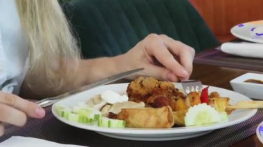 Bir kadın, modern bir kafe ortamında hoş bir yemeğin tadını çıkarıyor.