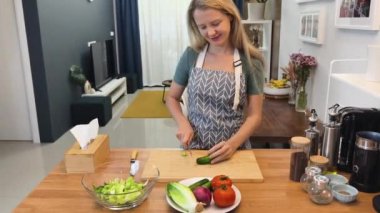 Taze sebzelerden ve çeşitli malzemelerden oluşan lezzetli bir salata pişiren bir şef. 