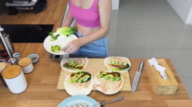 Çağdaş mutfakta Chiken Shawarma 'yı hazırlayan genç bir kadın.