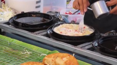 Usta bir aşçı dışarıda Tayland mutfağını tutkuyla pişiriyor.. 